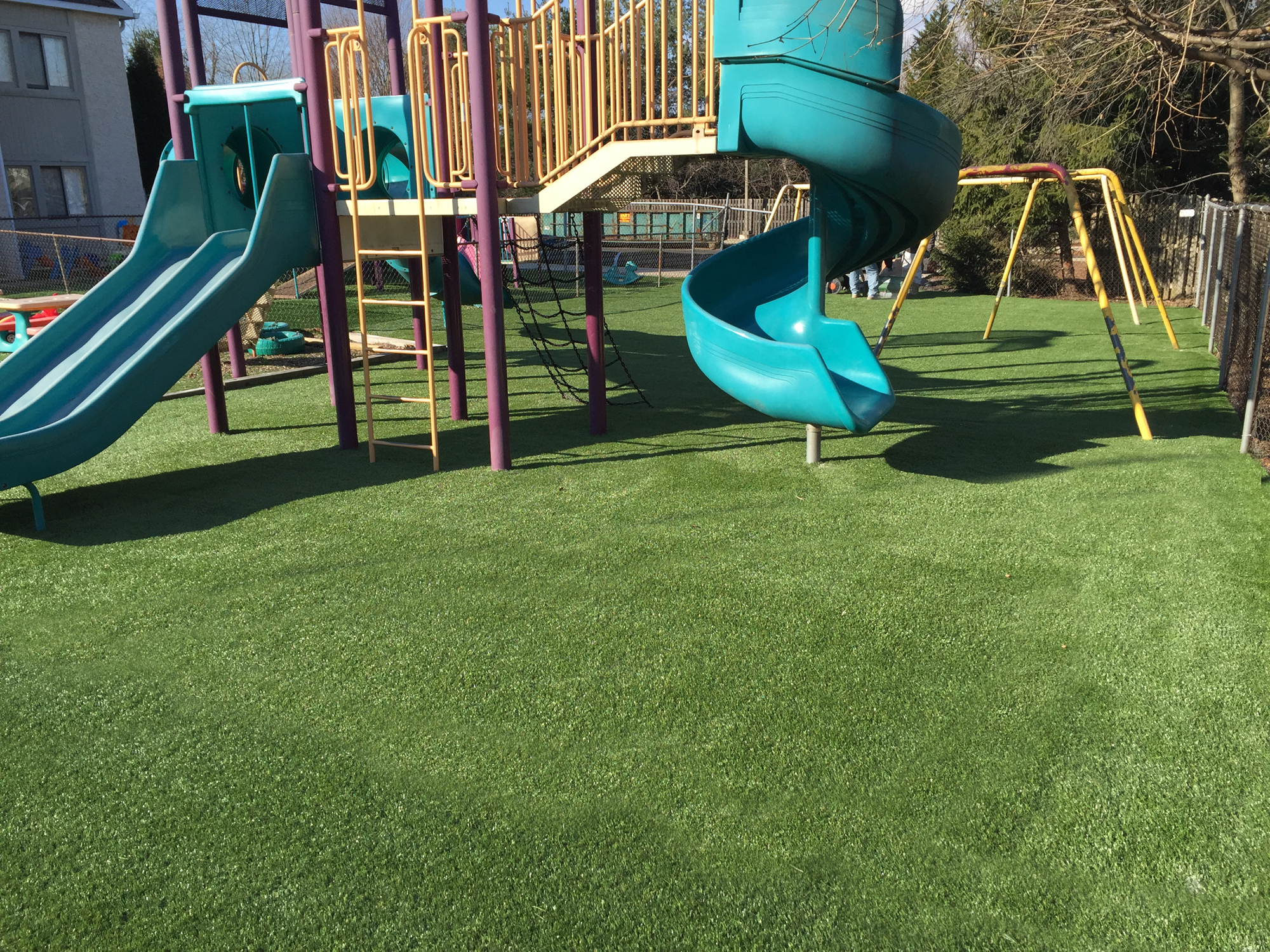 Colorful outdoor play equipment with artificial turf surface