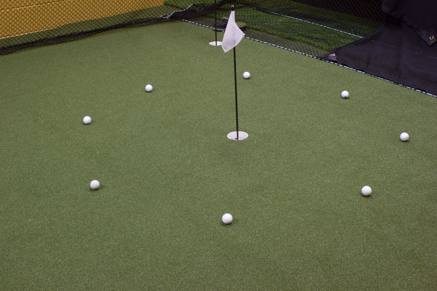 Golf balls circled around a pin on an indoor putting green in PA