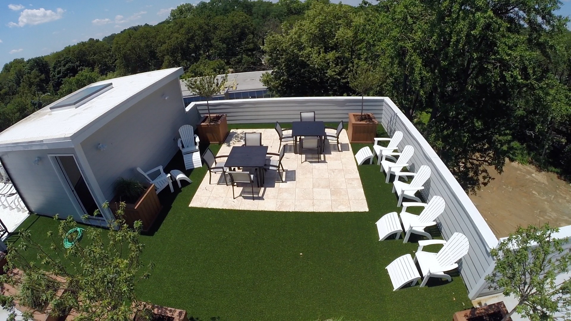 Roof top with an artificial turf patio lined with lounge chairs